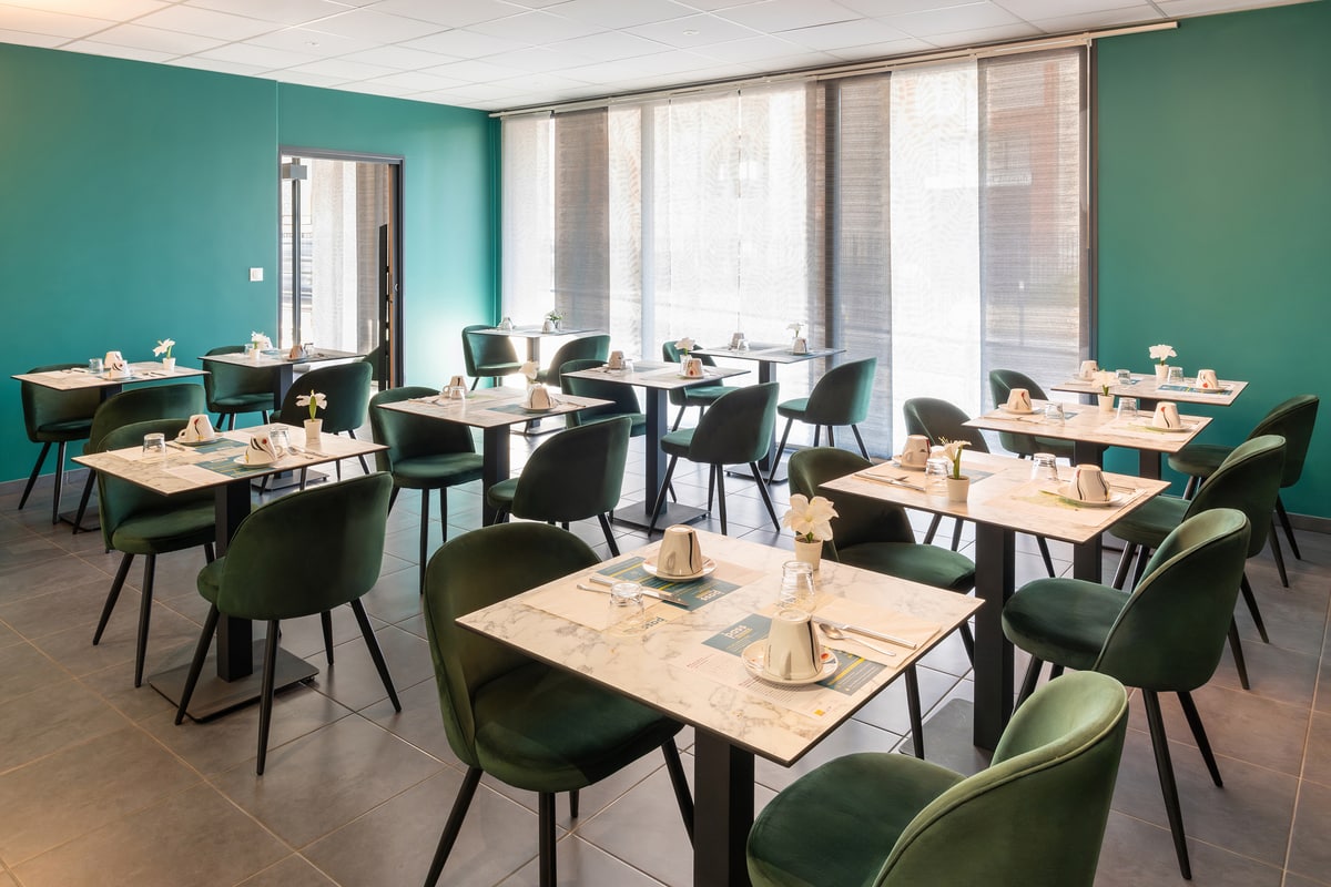 La salle de petit-déjeuner avec ses fauteuils verts